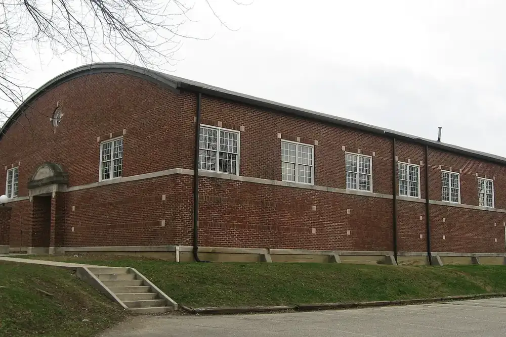 The historic arched-roof brick Mooresville Gymnasium on a grassy rise in Mooresville, Indiana